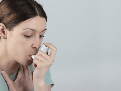 Woman taking asthma puffer before mattress cleaning Grimsby